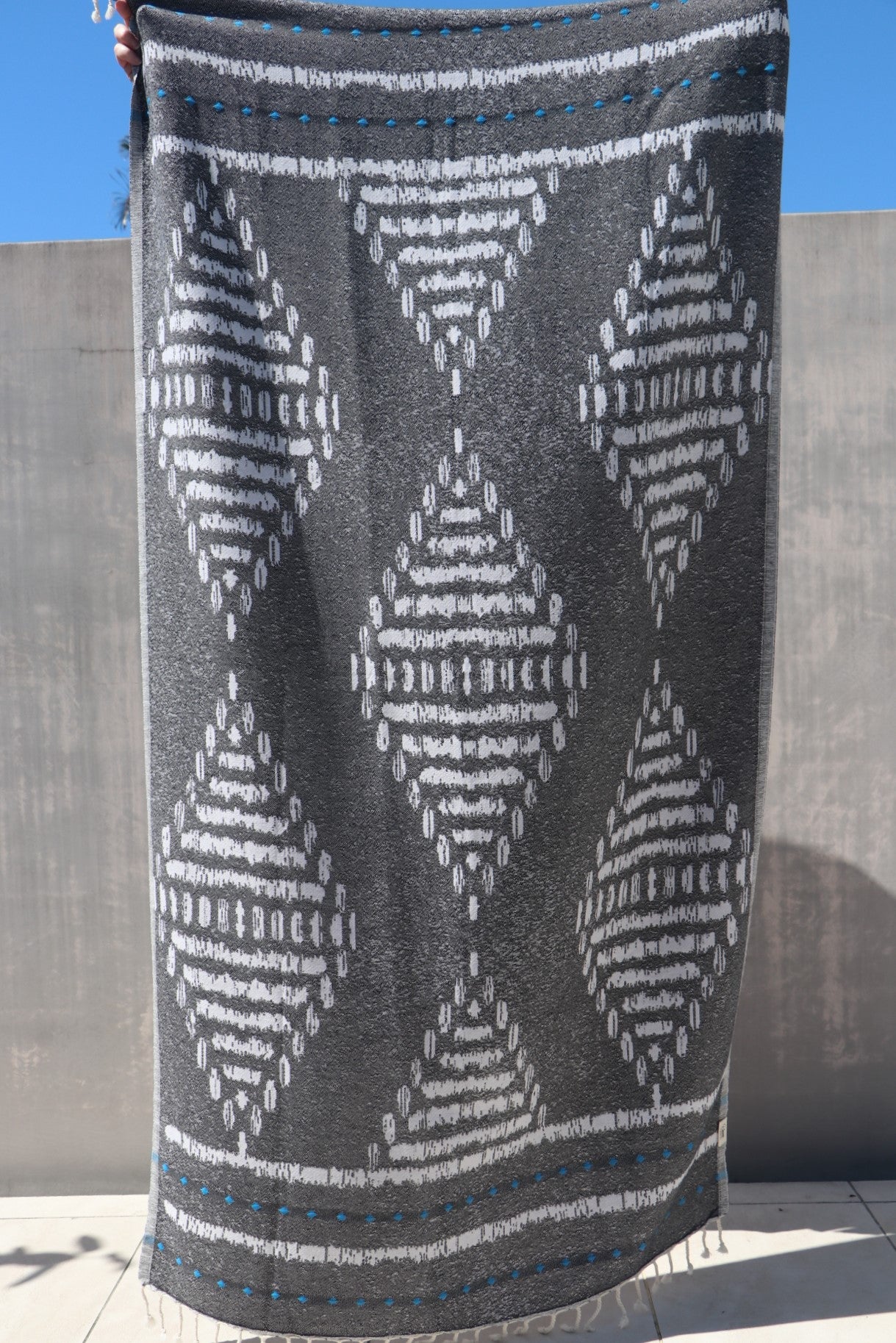 Black towel with large white diamond pattern shown full length
