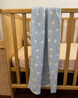 blue hearts cotton baby blanket displayed on a cot