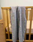 double sided baby blanket with dots shown on a cot