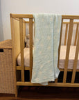 mint stars baby blanket displayed on a cot
