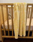 yellow stars baby blanket displayed on a cot