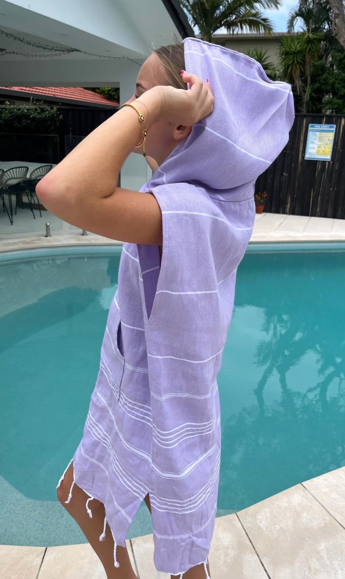 girl wearing lilac Classic hoodie by a pool